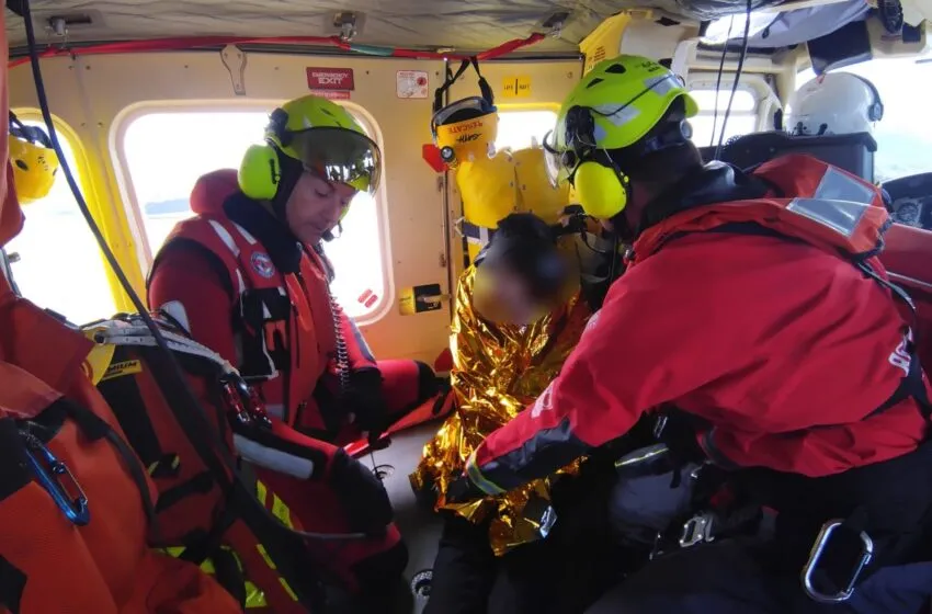 Rescate frente a la Isla de Mouro: el helicóptero del Gobierno de Cantabria evacúa a una remera tras volcar su trainera en Somo