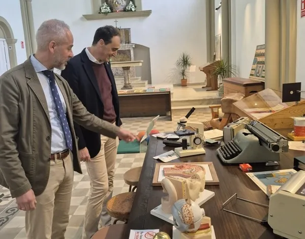 El consejero de Educación, Sergio Silva, junto al alcalde de Alfoz de Lloredo, Enrique Bretones, visitando la exposición sobre los 50 años del centro educativo. (Foto: Oficina de Comunicación)