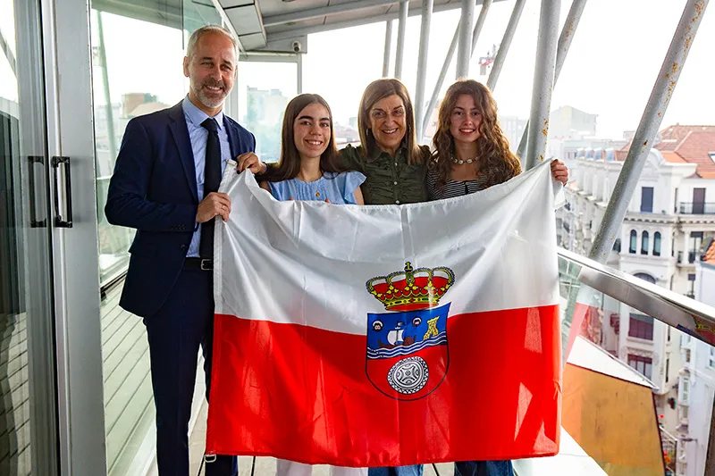 El consejero de Educación, Sergio Silva; Laura Trueba, la presidenta de Cantabria, María José Sáenz de Buruaga, y Elsa Gil con la bandera autonómica en la sede del Gobierno. FOTO: Miguel López