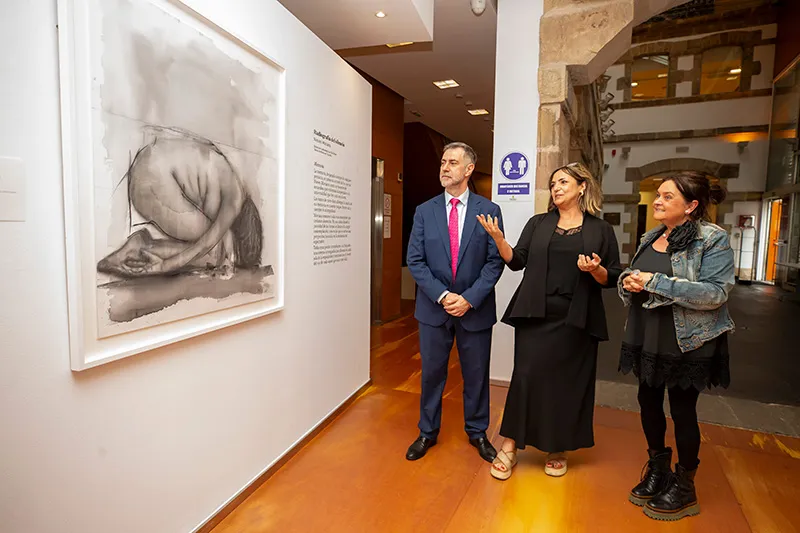 El consejero de Cultura, Luis Martínez Abad, junto a la pintora Nieves Moriano, visitando su exposición 'Radiografía del silencio' en la sala Mauro Muriedas de Torrelavega (Foto: Miguel López)