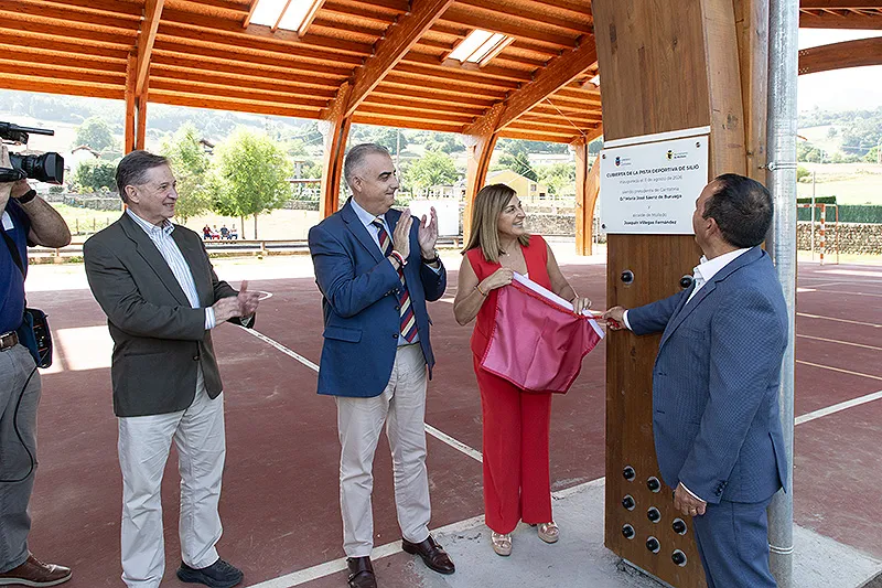 La presidenta y el alcalde del municipio descubren la placa durante la inauguración de la cubierta de la pista deportiva de Silió. FOTO: Patricia Pereda