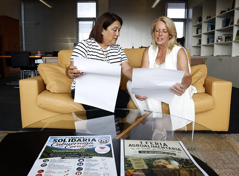 La consejera de Desarrollo Rural, María Jesús Susinos y la alcaldesa de Cabuérniga, Rosa Fernández, revisan los carteles de la Feria Agroalimentaria y la Marcha Solidaria (FOTO: Lara Revilla)